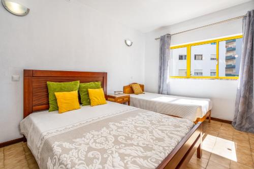 a bedroom with two beds and a window at Sweet Home Rp in Portimão