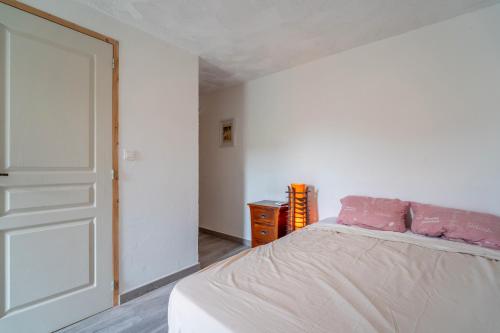 a bedroom with a bed with pink pillows on it at Gîte indépendant l'Orchidée in Lespignan