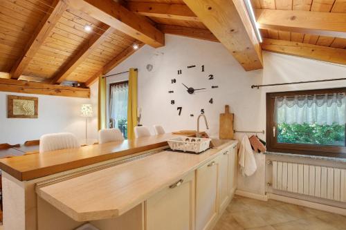 a kitchen with a large clock on the wall at Case Vacanza Newmood - Intera Villa in Aymavilles