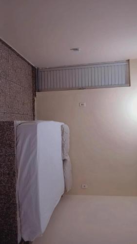 a room with a bed with a towel on it at Quarto de temporada in Belém