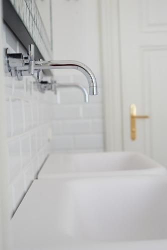a bathroom with a sink and a faucet at Hotel Landhaus Moserhof in Gumpoldskirchen