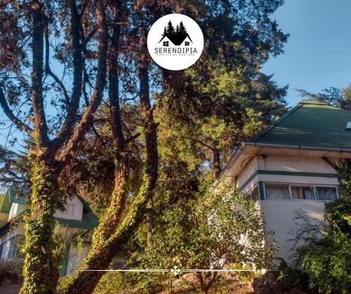 a house with a tree and a sign that says strawberry at Serendipia Chalet 1 Naturaleza y Pileta in La Cumbre