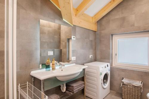 a bathroom with a sink and a washing machine at Cà Dei Nane Vermiglio in Vermiglio