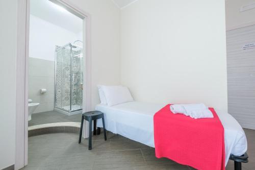 a bedroom with a white bed and a red blanket at Paladino in Giardini Naxos