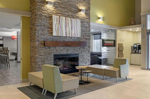 a lobby with a fireplace and a table and chairs at Best Western Plus Dartmouth Hotel & Suites in Halifax