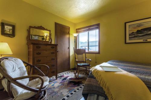 a bedroom with a bed and a chair and a window at Oceanfront Wave Watching with Hot Tub! Beyond the Sea in Yachats