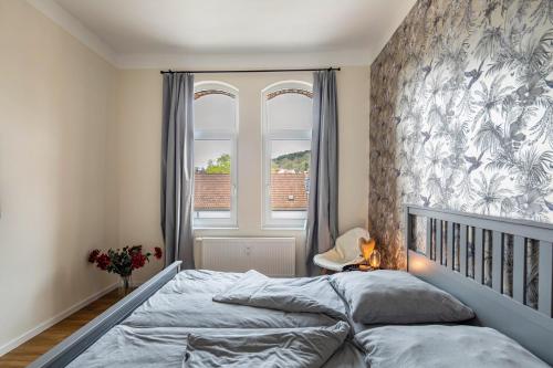 a bedroom with a bed and a large window at Residenz unter der Birke - Esche in Eisenach