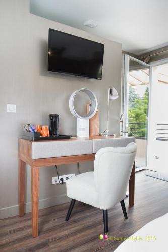 a desk with a white chair and a mirror at L'Hostellerie d'Acquigny in Acquigny