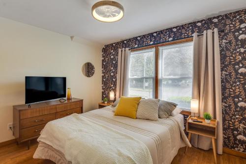 a bedroom with a bed and a tv and a window at 1 Mi to Dtwn Burlington Modern Home with Yard! in Burlington