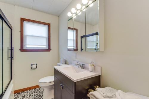 a bathroom with a sink and a toilet and a mirror at 1 Mi to Dtwn Burlington Modern Home with Yard! in Burlington