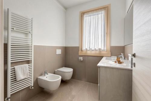 a bathroom with a toilet and a sink and a window at Agriturismo Le Campagnole Red in Bardolino