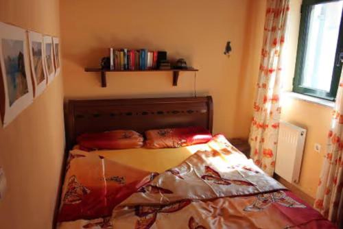 a bedroom with a bed in a room with a window at Ferienhaus Alexis - Zorbas in Kalathas