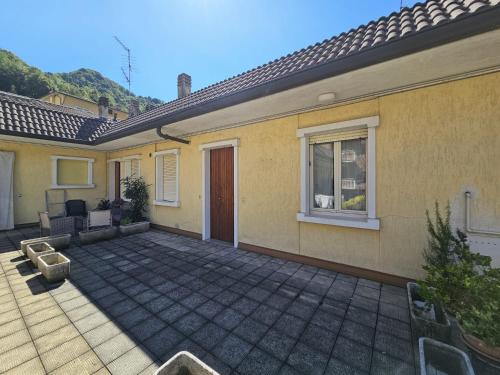 a home with a patio and a house at Riverside San Pellegrino in San Pellegrino Terme