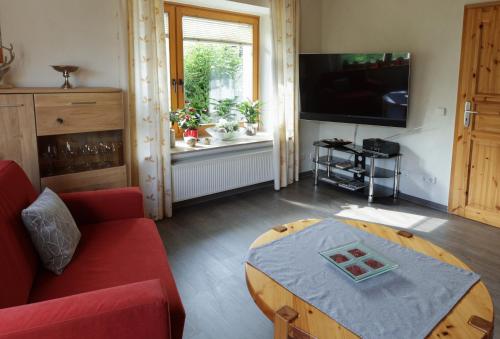a living room with a red couch and a table at Haus Stanek in Willingen