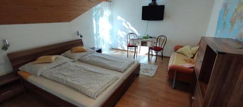 a bedroom with a large bed and a table at Ubytovanie michaela in Bešeňová