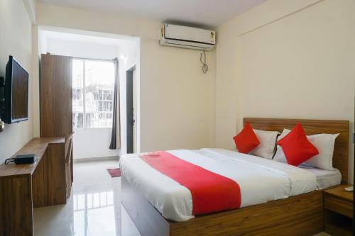 a bedroom with a large bed with red pillows at Collection O Palm Bliss in Kharadi