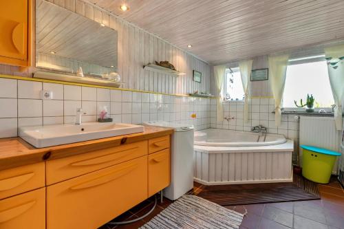 a bathroom with a sink and a bath tub at Ferienhaus Busch in Elpersbüttel