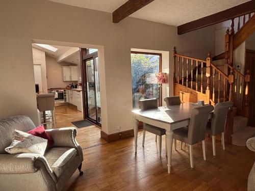 ein Esszimmer mit Tisch und Stühlen und eine Küche in der Unterkunft Stable Cottage Lytham in Lytham St Annes