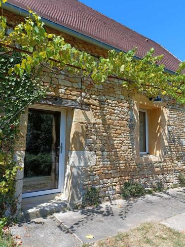 a stone house with a window and a door at Domaine de la Salamandre in Auriac-du-Périgord