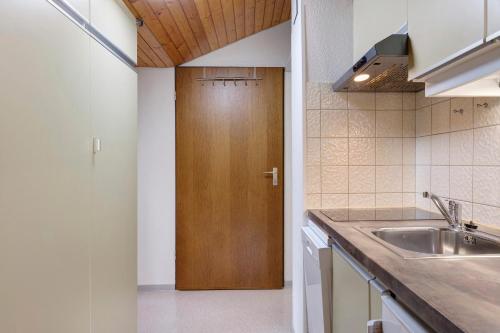 eine Küche mit einem Waschbecken und einer Holztür in der Unterkunft Gästehaus Himmelswiese Ingo Reetz in Schönwald