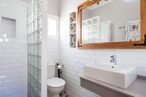 a white bathroom with a sink and a mirror at Casa Basallote in El Palmar