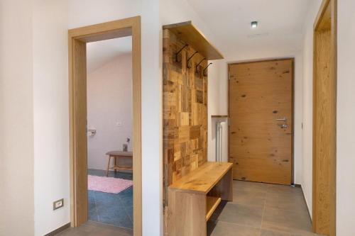 a hallway with a wooden door and a wooden bench at Ferienhaus Leitner in Tires