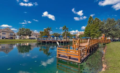 ein See mit einem Holzsteg mit einem Steg in der Unterkunft Luxury house in Disney in Kissimmee