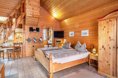 a bedroom with a bed in a wooden room at Blockhaus An Der Nordsee in Groß Olversum