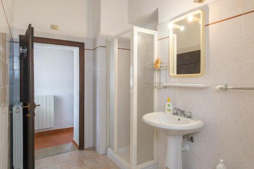 a white bathroom with a sink and a mirror at Santa Lina - Lavanda in Pomarance
