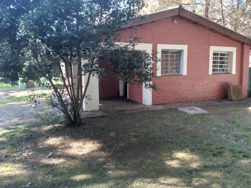 a red brick house with a tree in front of it at La casa de Susana en el candil in Solís