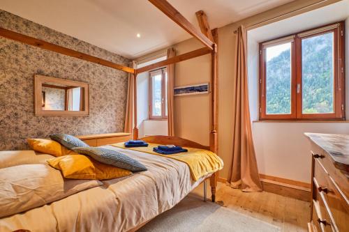 un dormitorio con una cama y una ventana en Jacuzzi Sauna Terrasse Venosc, en Les Deux Alpes