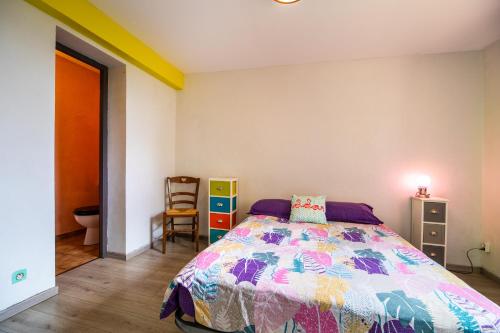 Un dormitorio con una cama con una colcha colorida. en Studio avec Jardin à Bagneres, en Bagnères-de-Bigorre
