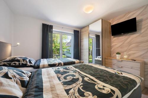 a bedroom with two beds and a flat screen tv at Gästehaus Anna in Suhle