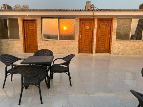 a table and chairs on a patio with a sunset at sun 3 pyramids view inn in Cairo