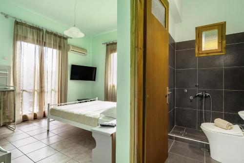 Un dormitorio con una cama y un baño con ducha. en Old Boat double studio 5, en Nikiana