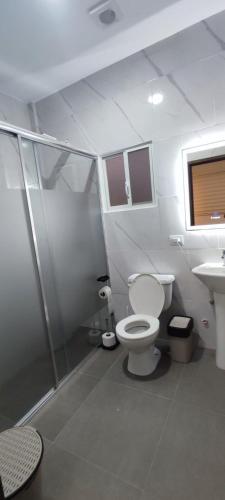 a bathroom with a toilet and a shower and a sink at Amathea Imperial in Machala