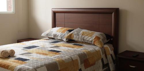 1 cama con edredón y 2 almohadas en Amathea Imperial, en Machala