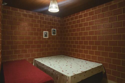 a room with a bed in a brick wall at Casa Maré Alta – Piscina e Sossego em Tabuba in Santa Luzia