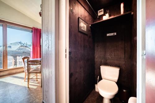 een badkamer met een toilet, een tafel en een raam bij Les Pralyssimes - 35 M² in Taninges