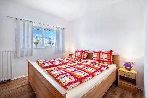 a bedroom with a bed and a window at Ferienwohnungen Hof Am Deich in Hillgroven