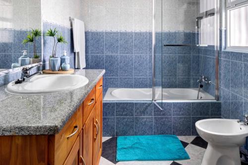 a bathroom with two sinks and a tub and a shower at Casa Xadrez in Povoação