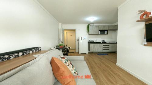 Una sala de estar con un sofá y una cocina. en Apartamento em Bauru em Frente ao Aeroporto, en Bauru
