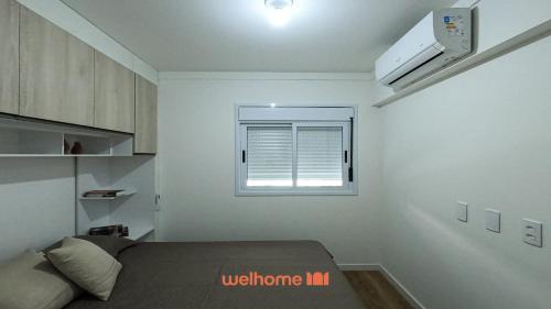 Apartamento em Bauru em Frente ao Aeroporto في Bauru: غرفة صغيرة بها سرير ونافذة