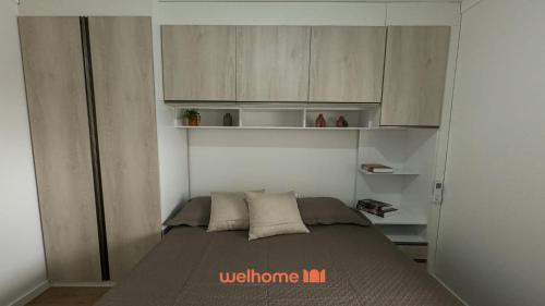 Apartamento em Bauru em Frente ao Aeroporto في Bauru: غرفة نوم صغيرة مع سرير وخزانة