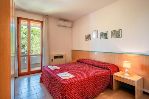 a bedroom with a red bed and a window at Albergo Il Tegolo in Cerreto Guidi