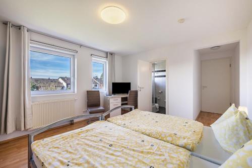 a bedroom with two beds and a desk and a window at Gästezimmer Gross in Tübingen