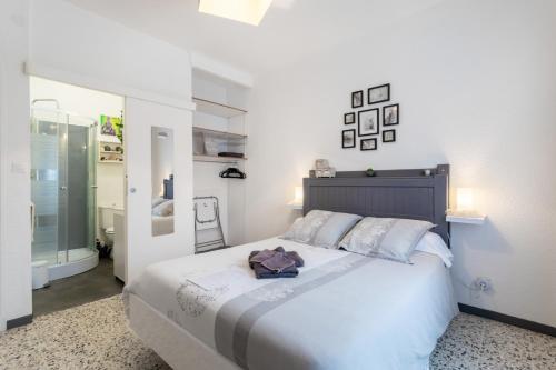 a bedroom with a large white bed and a mirror at Chambres D'hotes Au Bougainvillier in Perpignan