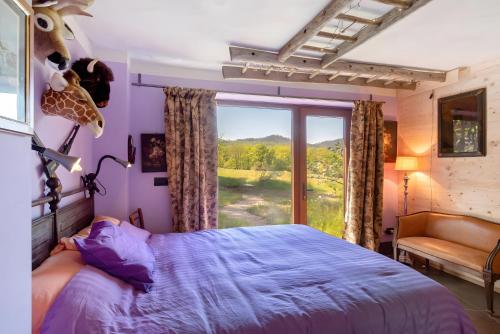 a bedroom with a bed and a large window at Borgo Tassani in Casaleggio Boiro