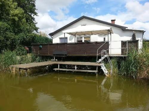 a house sitting on top of a body of water at Haus 'am Selliner See-wismar' in Neukloster