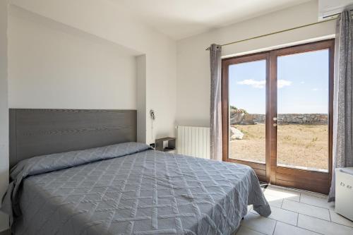 a bedroom with a bed and a large window at Casa Ami in Arzana